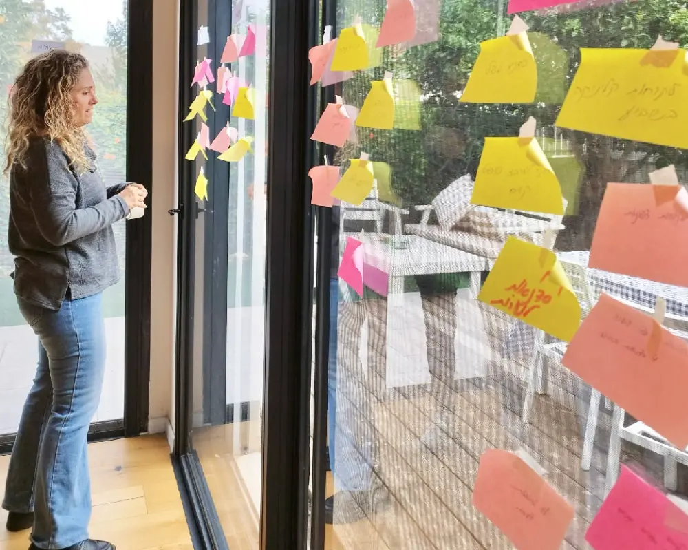 דנה מתבוננת בפתקי משימות